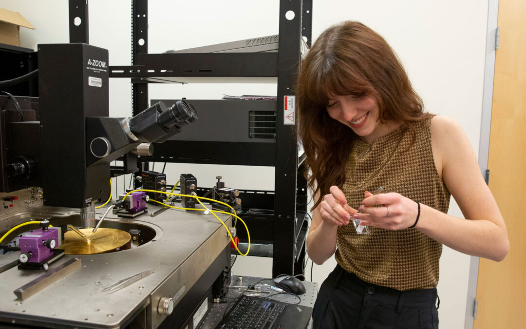 A student works with semiconductor research equipment in a lab.