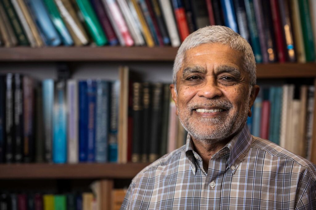 Vijay Vittal stands in front of a bookcase