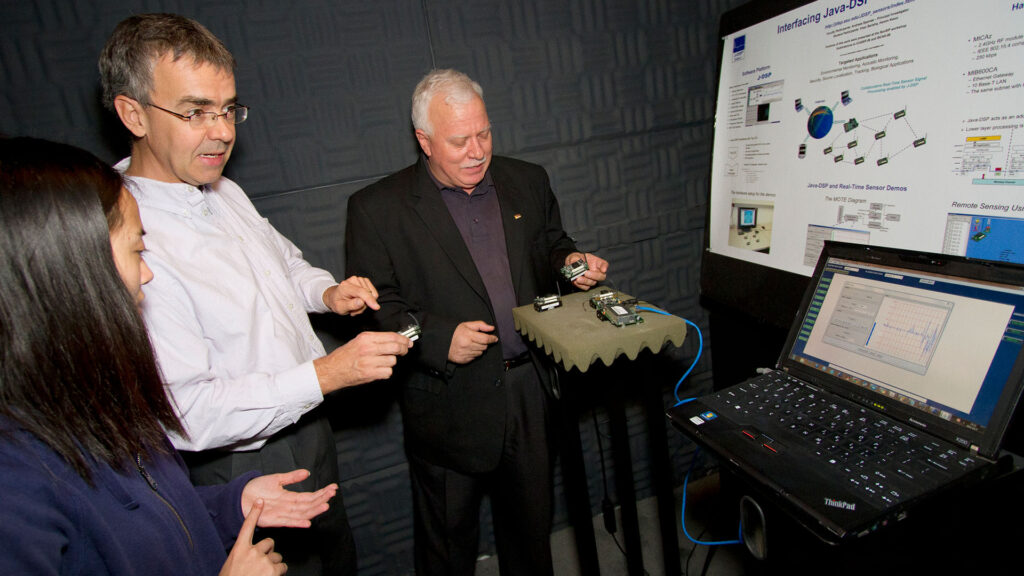 People conducting research on computer chips with antennas in the anechoic chamber at ASU