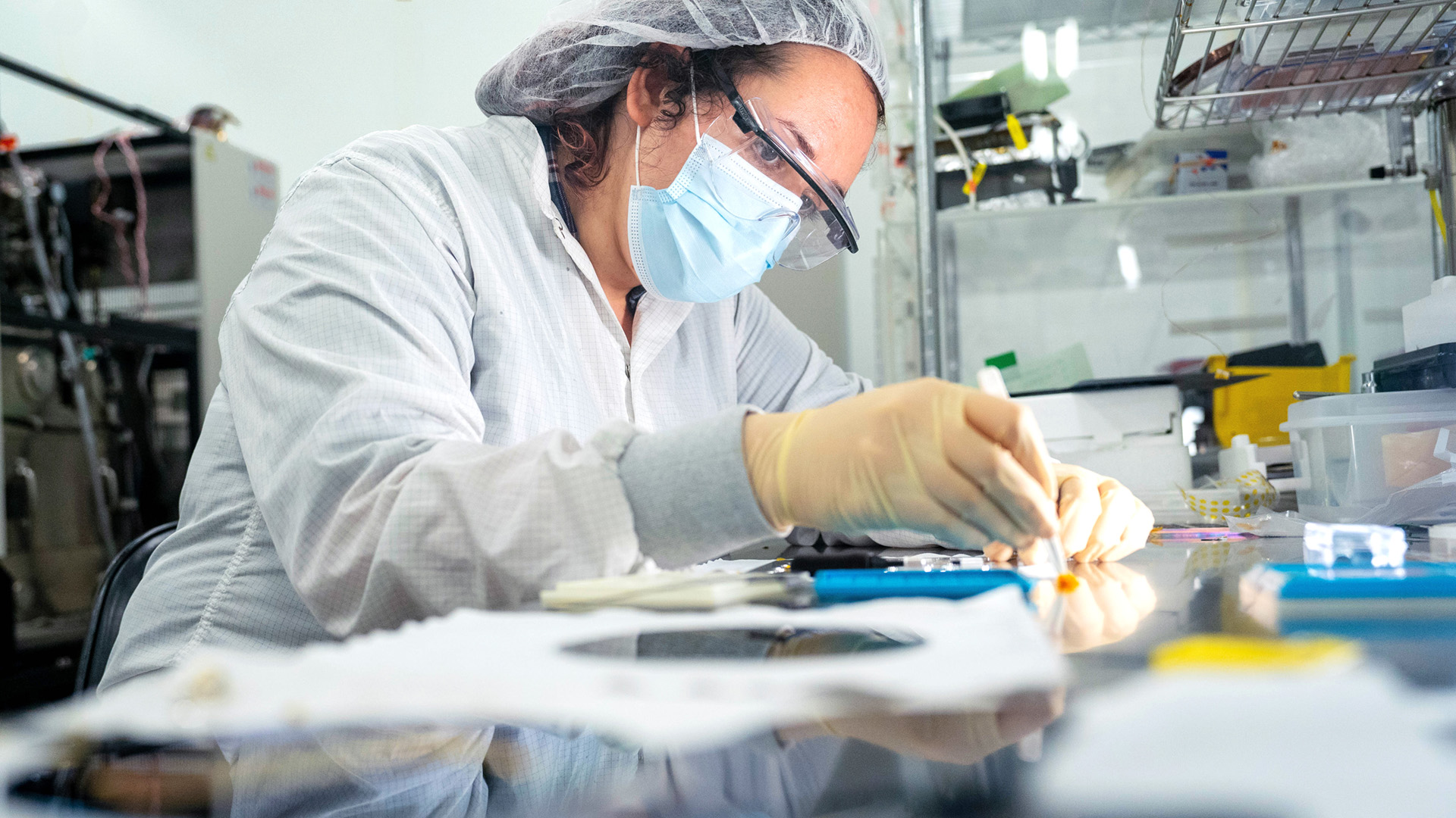 A researcher works with semiconductor material in a lab