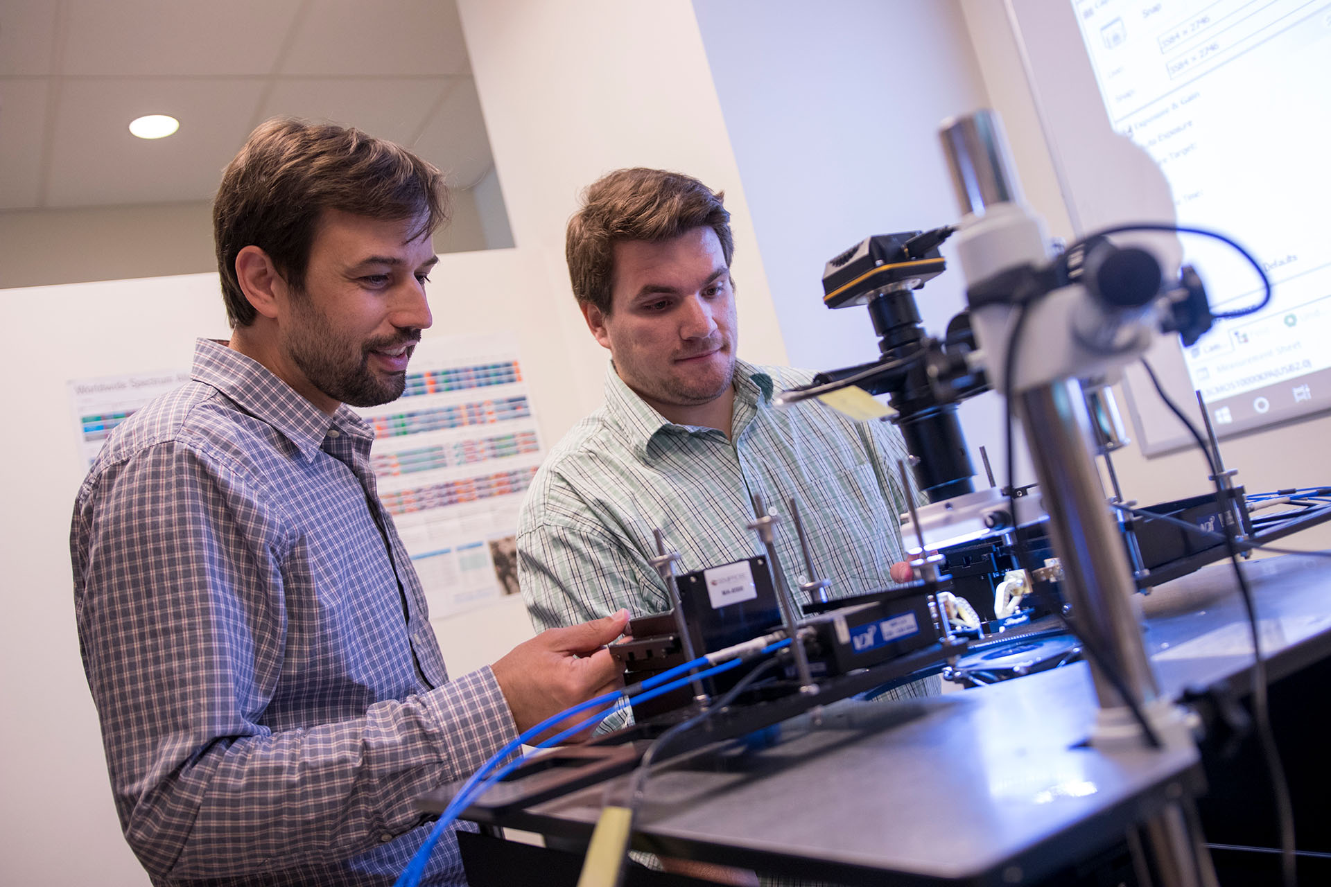 Two men experiment on electrical technology in a lab